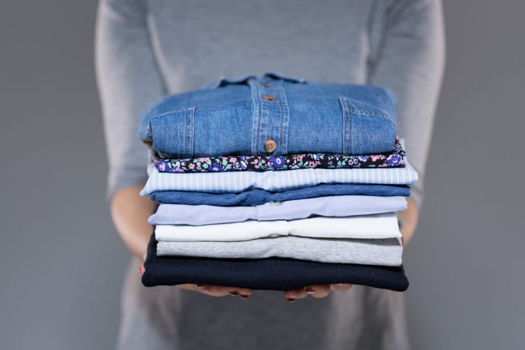 Person holding folded stack of laundry