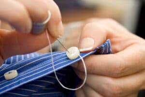 Threading a needle through a button